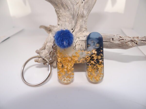 Porte clés lettre "H" avec pompon bleu