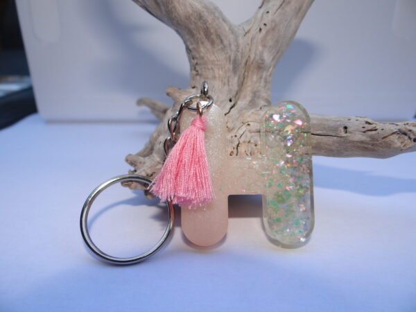 Porte clés lettre "H" blanc pailleté avec pompon rose