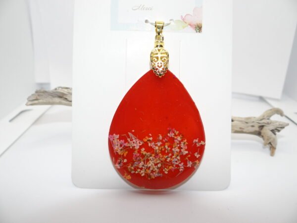 Pendentif rouge avec fleurs blanches