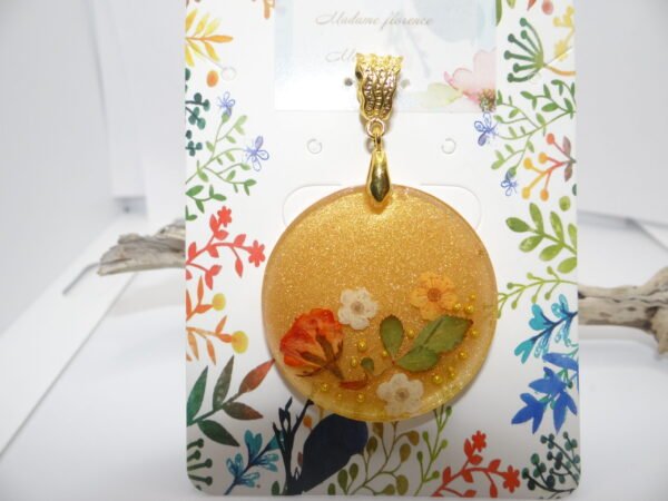 Pendentif rond jaune pailleté avec fleurs